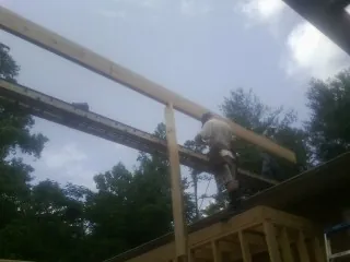 Carpenter setting a ridge beam over a new addition frame in Elk Creek